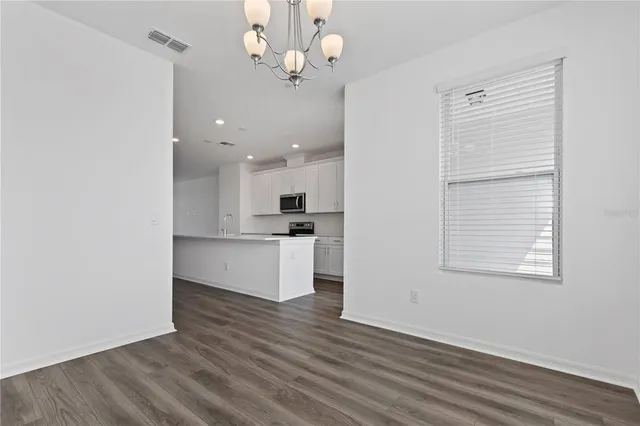 a view of kitchen with granite countertop cabinets and refrigerator