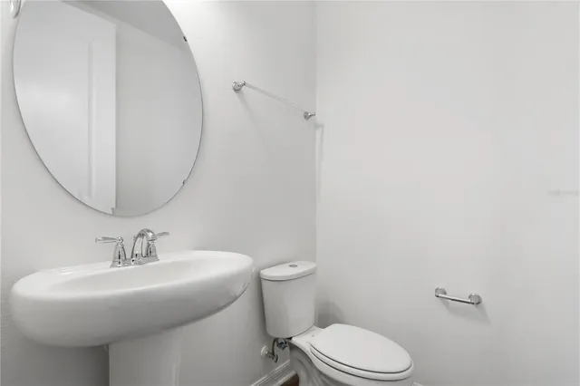 a bathroom with a sink toilet and a mirror