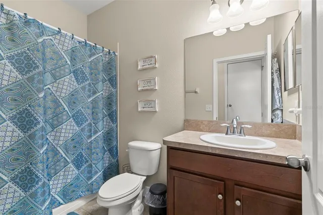 a bathroom with a sink vanity mirror and toilet