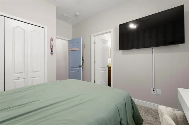 a bedroom with a bed and a flat screen tv