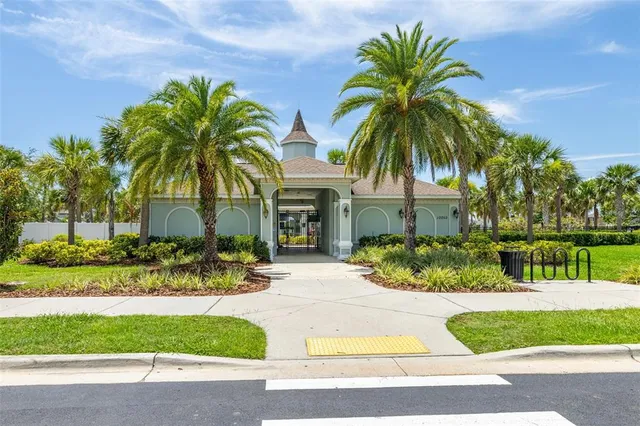 a view of a house with a yard and palm trees