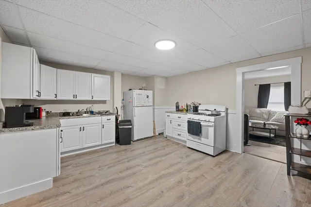 a kitchen with white cabinets and white appliances