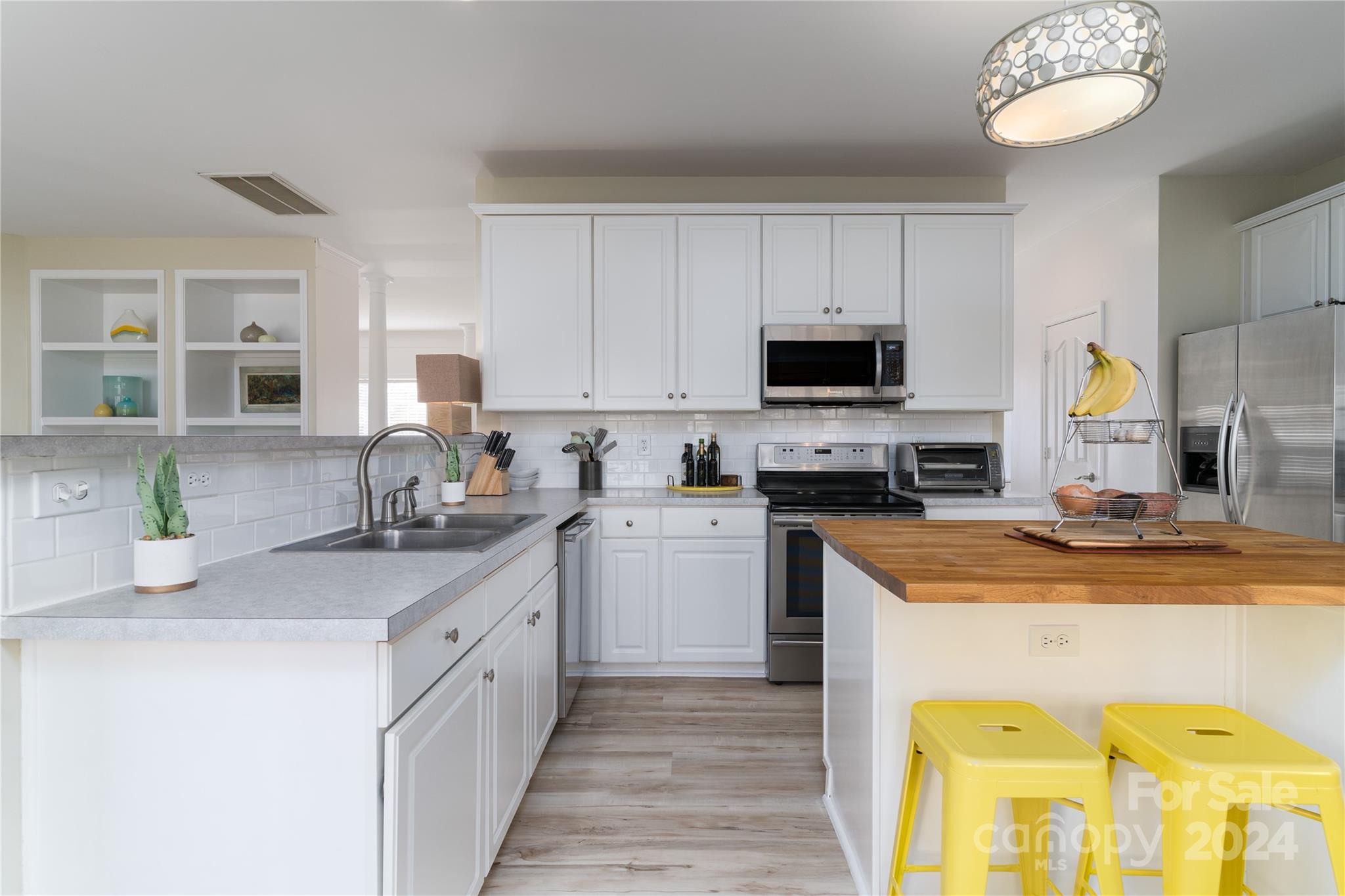 9427 Culcairn Road Huntersville, NC 28078 - Photo 13 of 39 a kitchen with a sink a stove top oven a counter space and cabinets