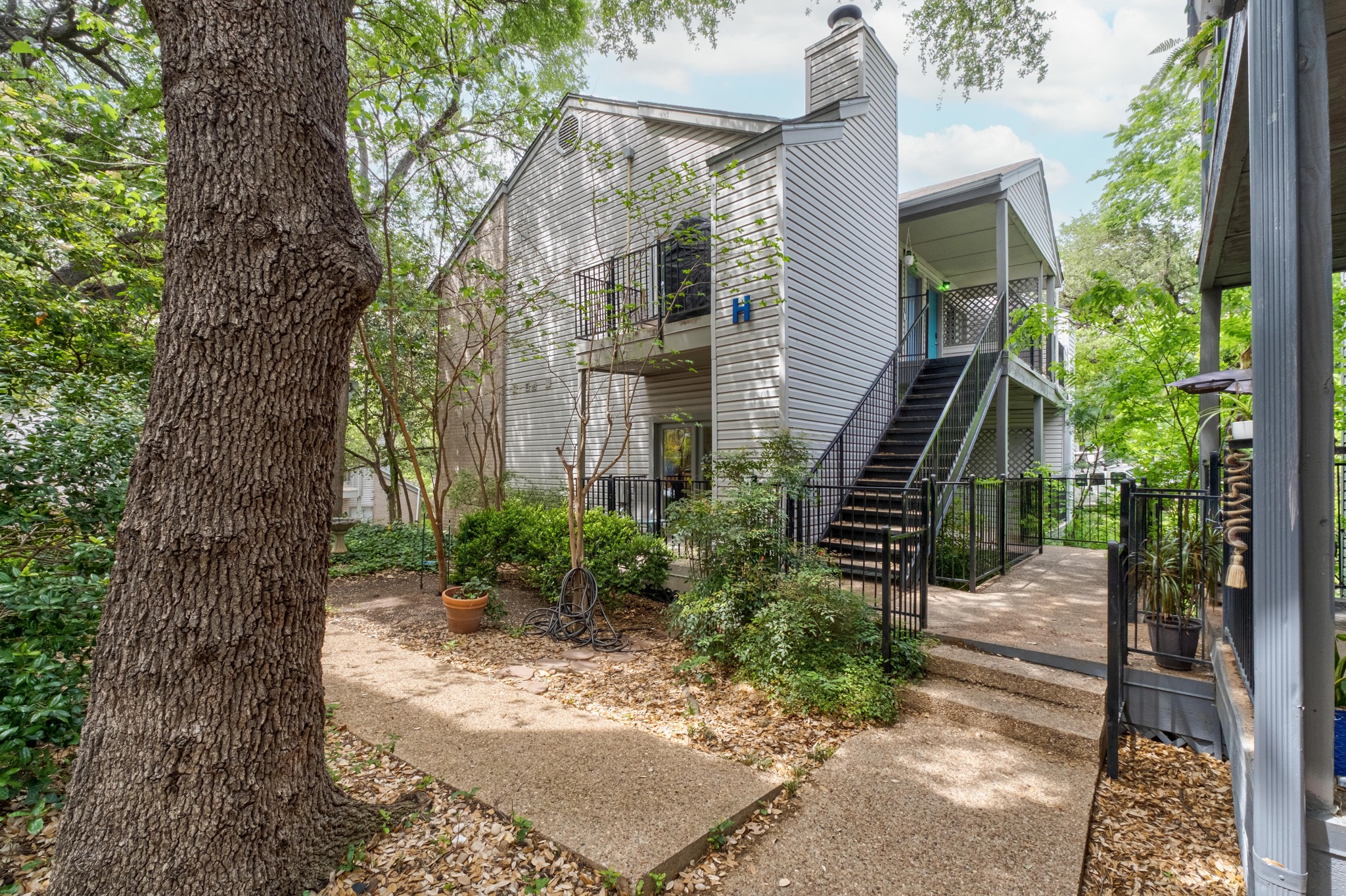 802 South 1st Street, Unit 115 Austin, TX 78704 - Photo 1 of 21 a front view of a house with a tree