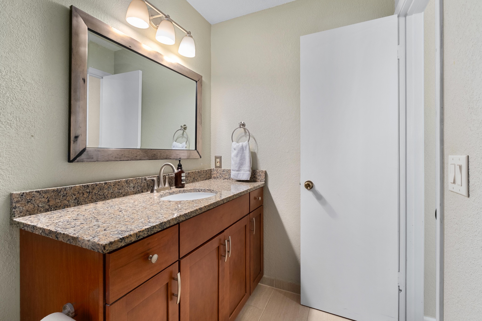 802 South 1st Street, Unit 115 Austin, TX 78704 - Photo 16 of 21 a bathroom with a granite countertop sink and a mirror