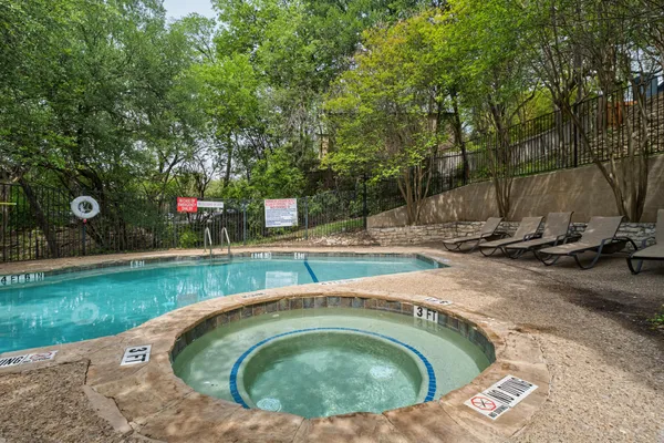 a view of swimming pool with a bench and trees