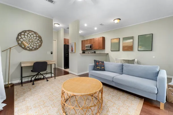 a living room with furniture a wooden floor and a large window