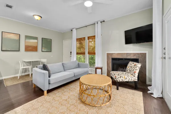 a living room with furniture a fireplace and a flat screen tv