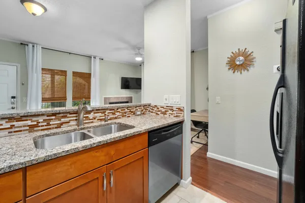 a kitchen with stainless steel appliances granite countertop a sink and a refrigerator