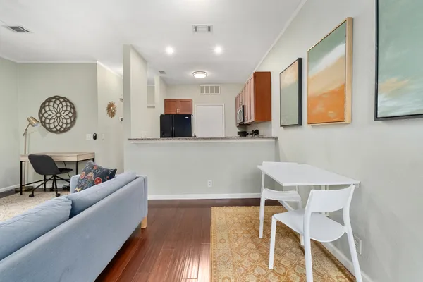 a living room with furniture and a wooden floor
