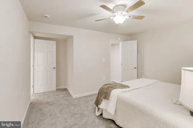 a bedroom with a bed and a ceiling fan