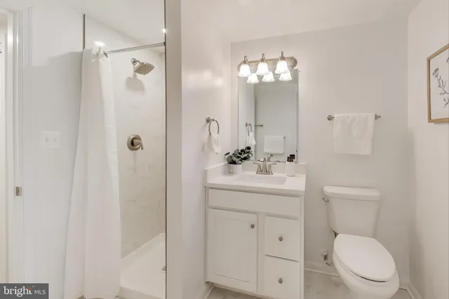 a bathroom with a toilet a sink a mirror a vanity and window