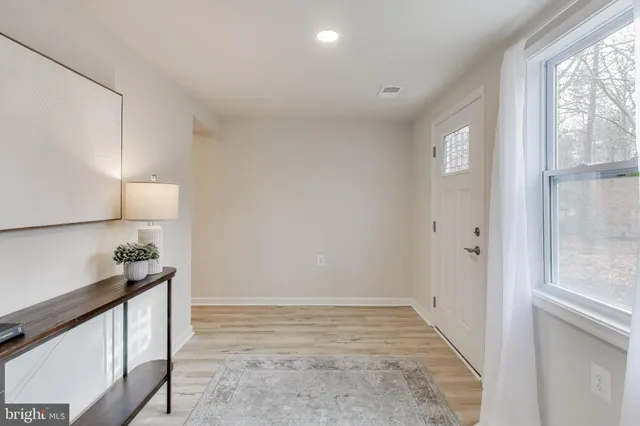 a view of hallway with a window and chandelier