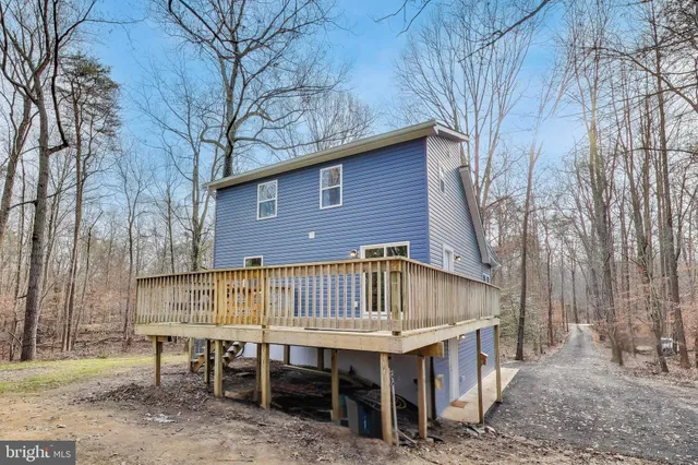 a view of a house with a deck and backyard