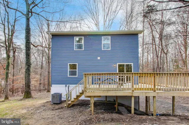 a brick house with a bench next to a yard