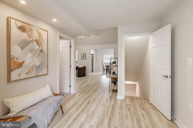 a view of a hallway with wooden floor and furniture