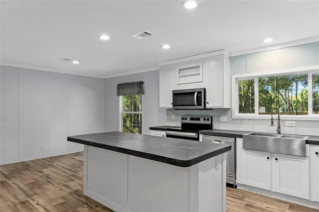 a kitchen with granite countertop a sink and a stove top oven