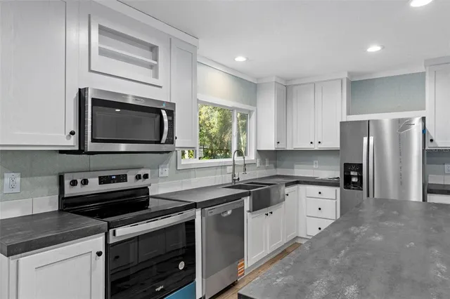 a kitchen with stainless steel appliances granite countertop a stove microwave sink and refrigerator