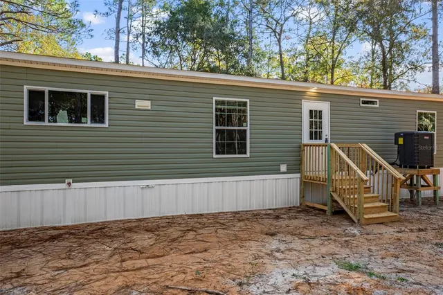 a view of a house with backyard and wooden fence