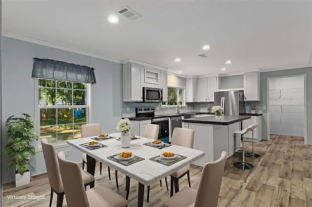 a kitchen with a dining table chairs and refrigerator