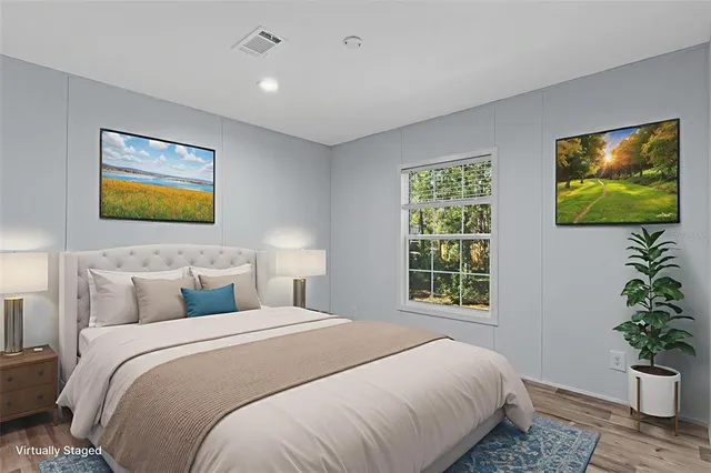 a bedroom with a bed and a painting on the wall