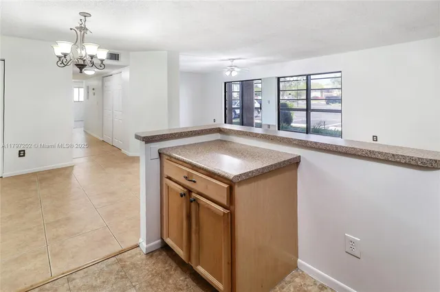 a view of a kitchen with a sink and chandelier