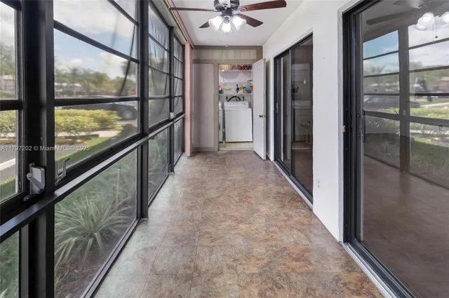 a view of hallway with a large window and chandelier