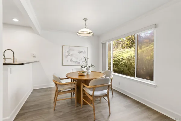 a dining room with furniture a chandelier and wooden floor