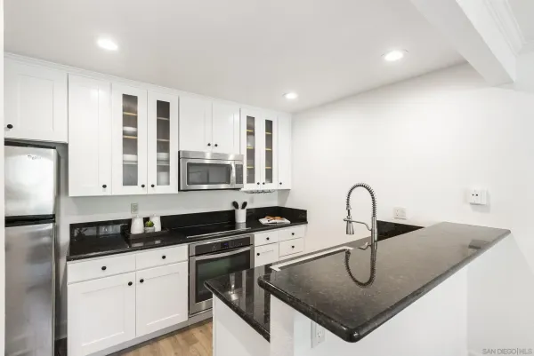 a kitchen with a sink a stove and cabinets