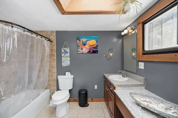 a bathroom with a granite countertop sink mirror vanity and toilet