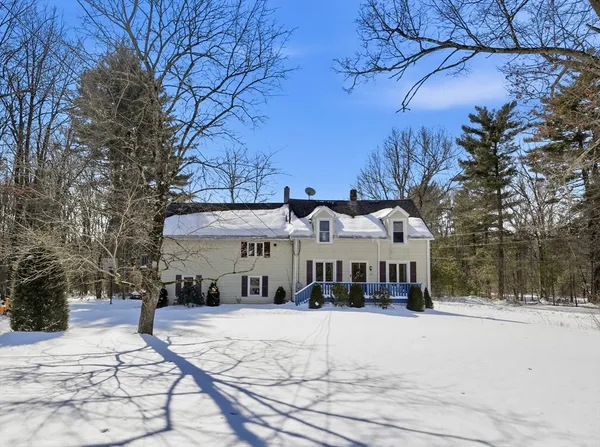a view of a white house with a large tree in front of it