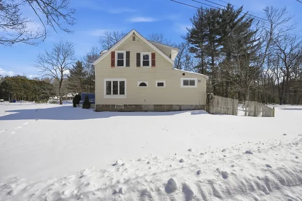 a front view of a house with a yard covered in snow