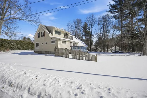 a view of a white house with a yard covered in snow
