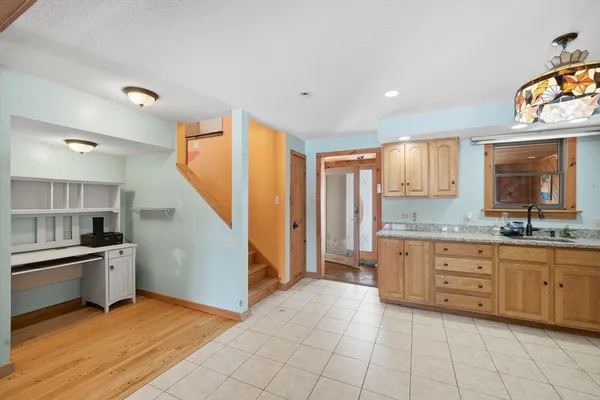 a kitchen with granite countertop a stove a sink and a refrigerator