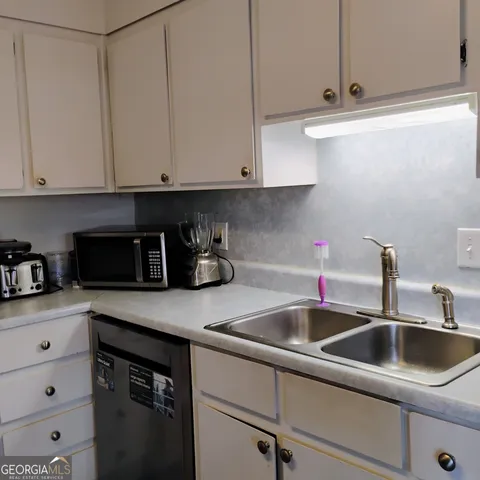 a kitchen with white cabinets and a sink
