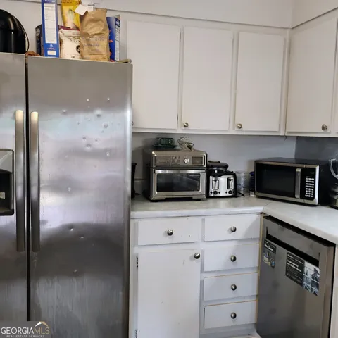 a kitchen with white cabinets and white appliances