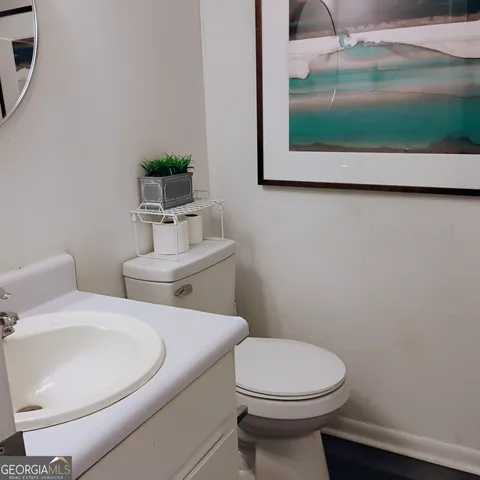 a bathroom with a toilet sink and mirror