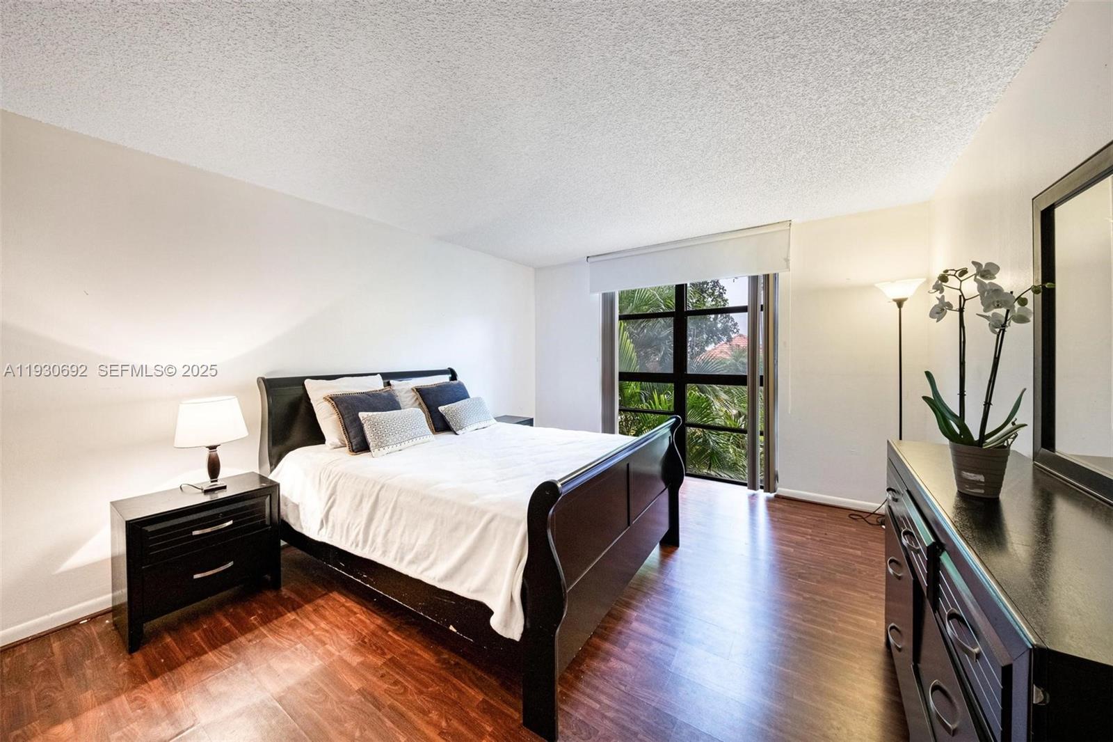 2000 Towerside Terrace, Unit 412 Miami, FL 33138 - Photo 13 of 57 a bedroom with a bed and a flat tv screen on dresser