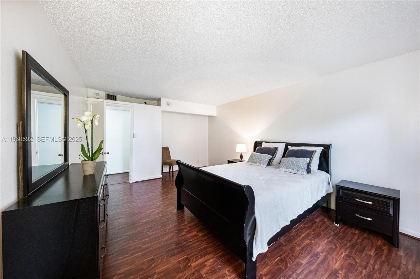 2000 Towerside Terrace, Unit 412 Miami, FL 33138 - Photo 15 of 57 a bedroom with a bed and a wooden floor