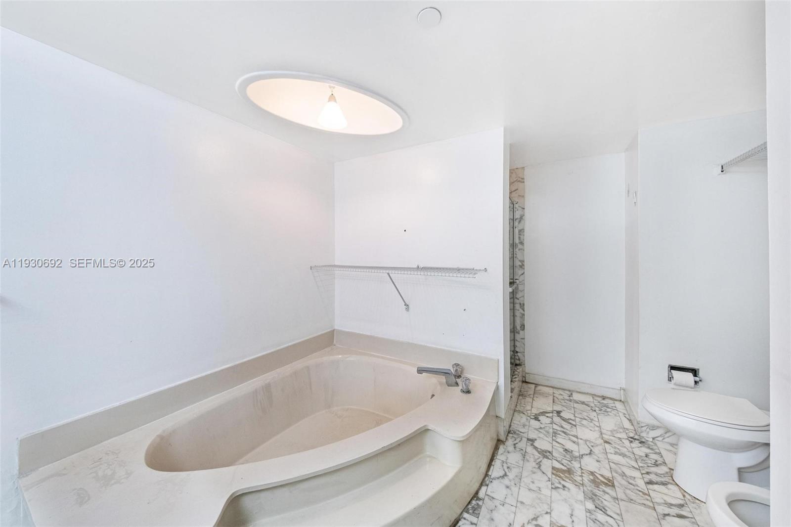 2000 Towerside Terrace, Unit 412 Miami, FL 33138 - Photo 16 of 57 a bathroom with a tub and a toilet