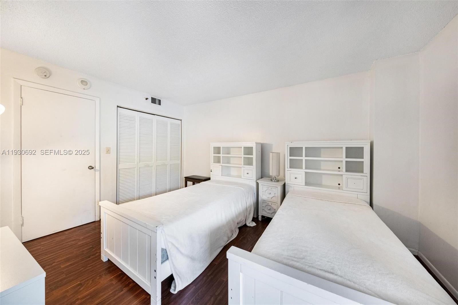 2000 Towerside Terrace, Unit 412 Miami, FL 33138 - Photo 18 of 57 a bedroom with a large bed and wooden floor