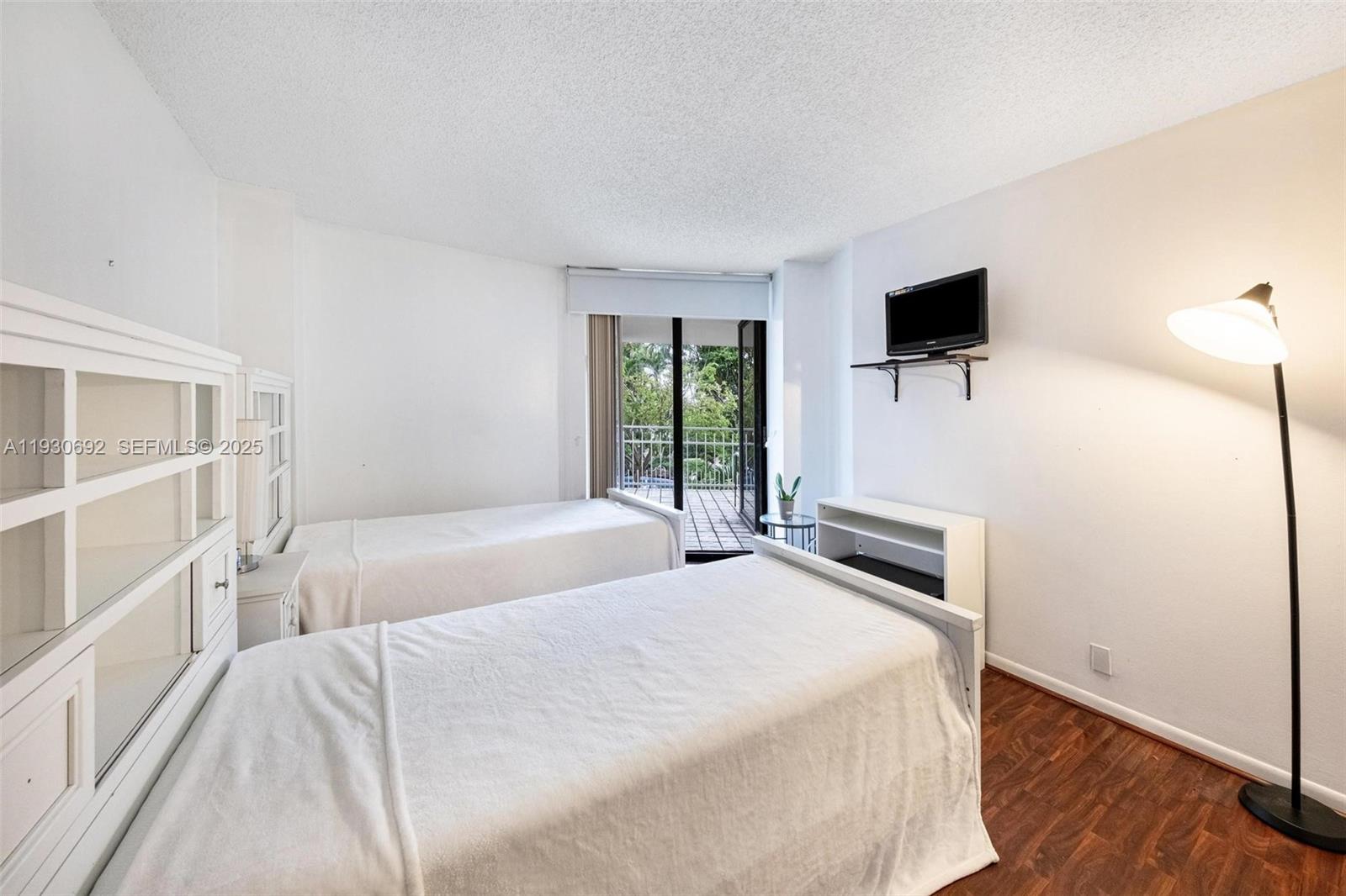 2000 Towerside Terrace, Unit 412 Miami, FL 33138 - Photo 20 of 57 a bedroom with a bed and a tv