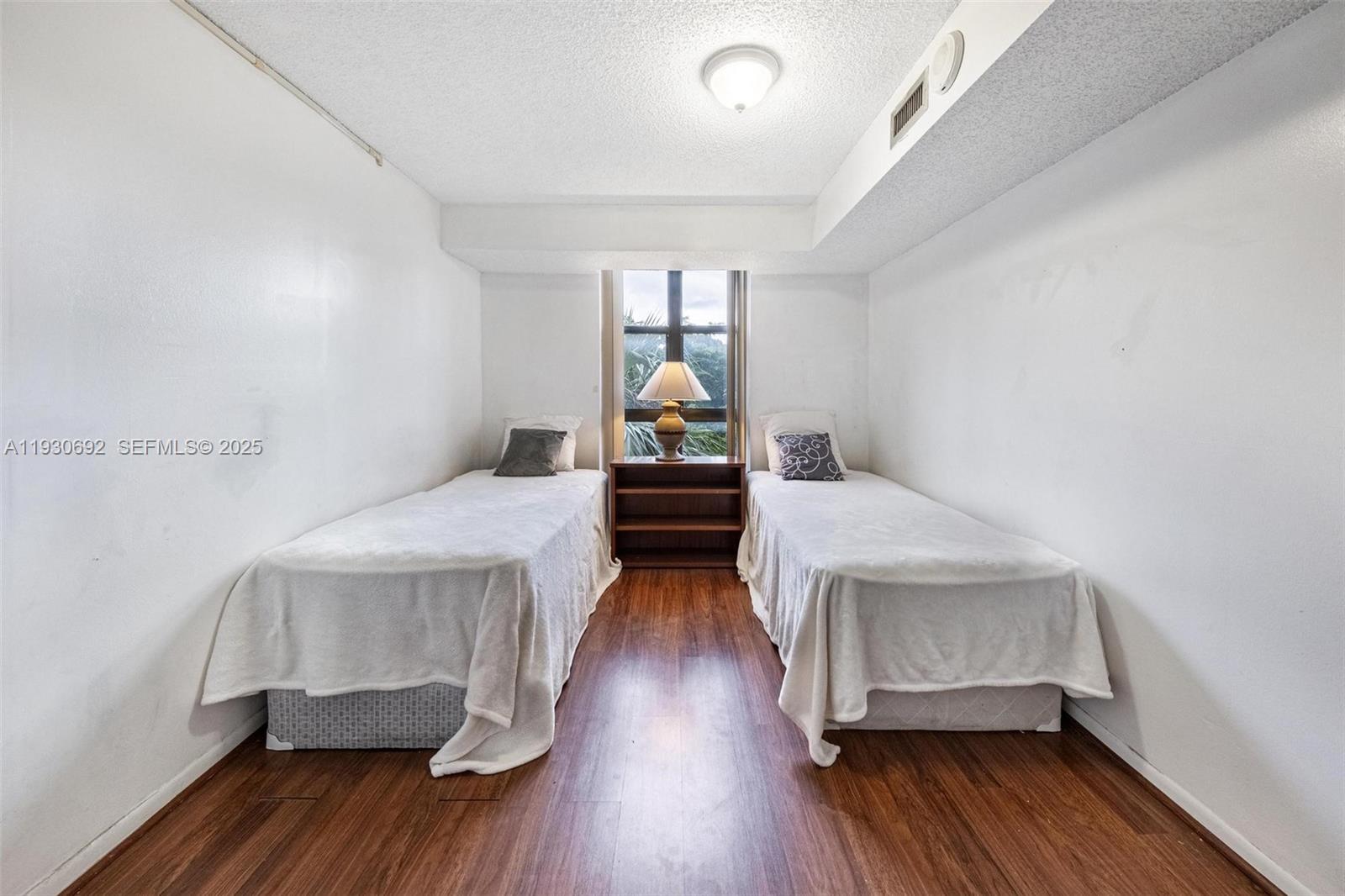 2000 Towerside Terrace, Unit 412 Miami, FL 33138 - Photo 22 of 57 a bedroom with wooden floor and bed