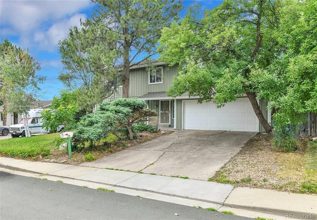 front view of a house with a yard and an trees