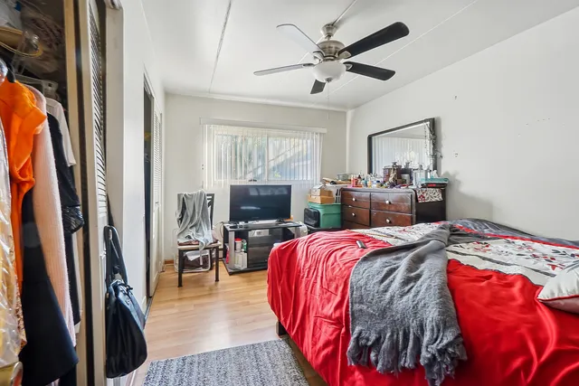 a bedroom with a bed a flat screen tv and dresser
