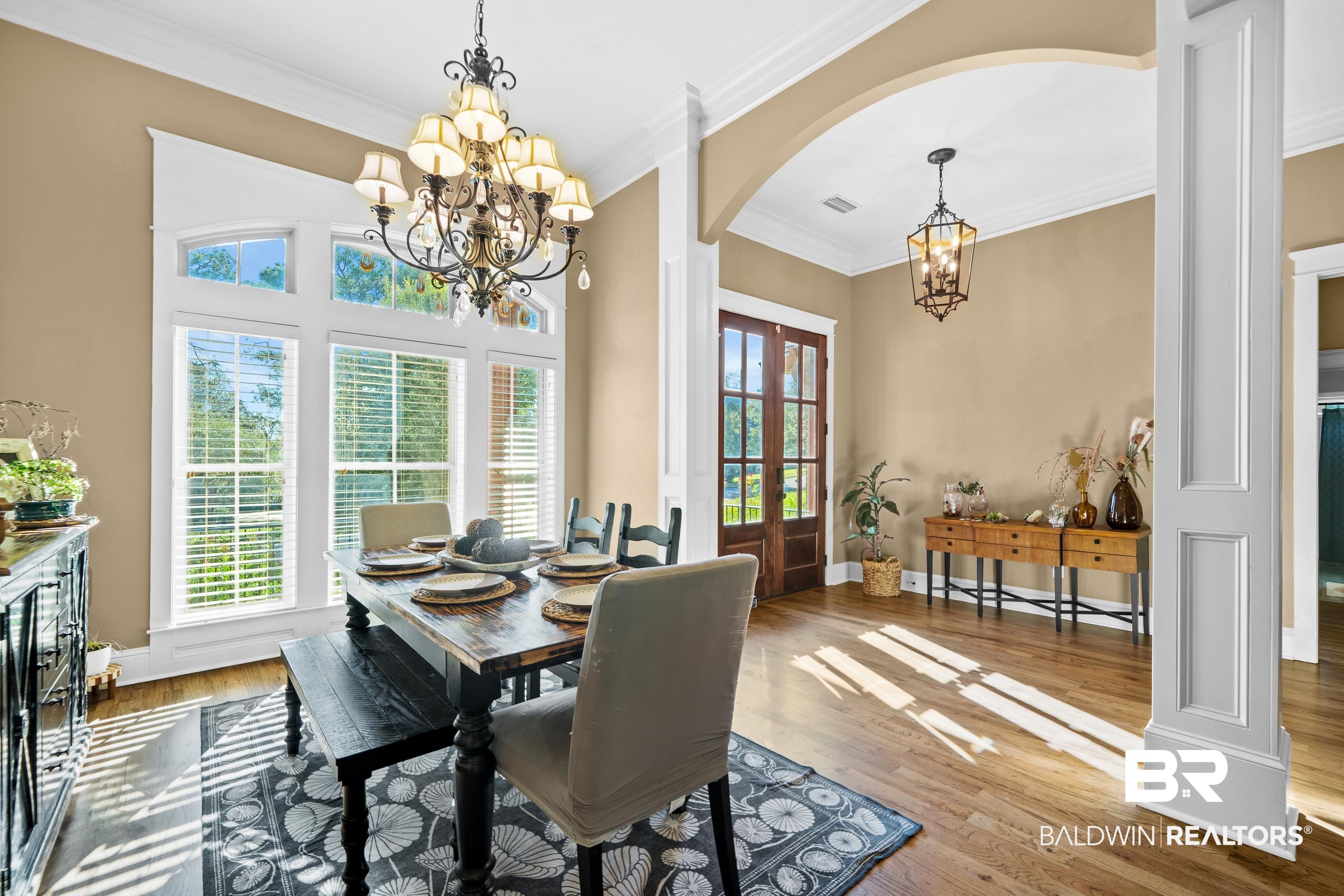 31829 Butler Drive Daphne, AL 36527 - Photo 13 of 48 Dining room with ornamental molding, wood-type flooring, and a notable chandelier