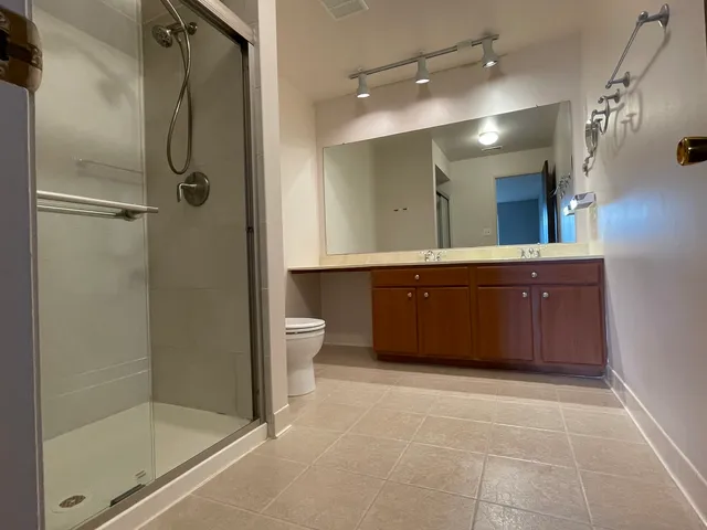 a spacious bathroom with a shower sink and mirror