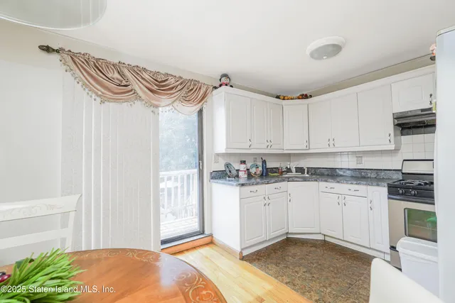 a kitchen with granite countertop a sink a stove and cabinets