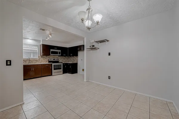 a large white kitchen with a sink stainless steel appliances and cabinets