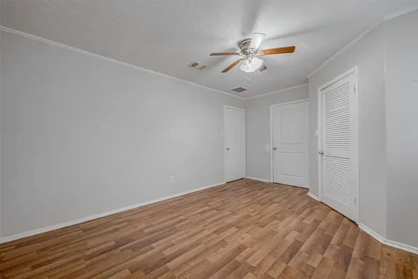 a view of an empty room with wooden floor